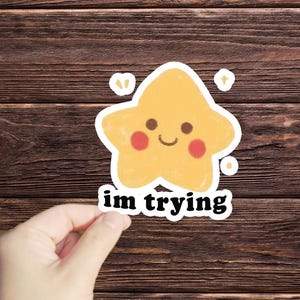 May include: A yellow star with a smiling face and rosy cheeks, with the text "im trying" below it.