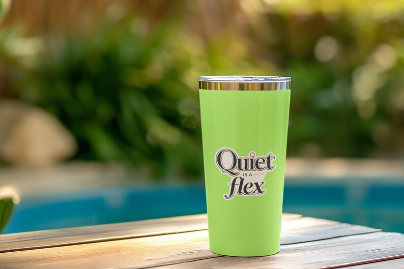 May include: A lime green insulated tumbler with a silver rim and lid. The tumbler has the phrase "Quiet is a flex" in a black and white sticker. The tumbler is sitting on a wooden surface with a blurred background of a pool and greenery.