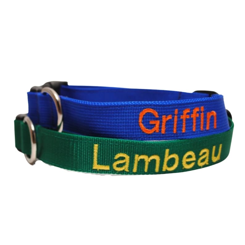 May include: Two nylon pet collars stacked together. The top collar is blue with the name Griffin embroidered in orange thread. The bottom collar is green with the name Lambeau embroidered in yellow thread. Both collars feature silver metal D-rings.