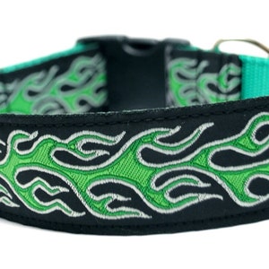 May include: A black dog collar with a green and silver flame design. The collar is made of durable nylon and has a metal buckle.