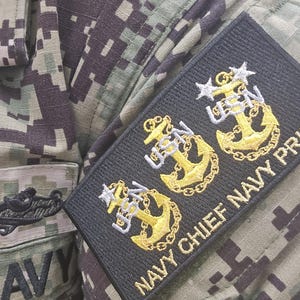 Embroidered military patch attached to a Navy Working Uniform sleeve, showcasing three gold USN anchors with stars representing Chief, Senior Chief, and Master Chief ranks. The patch reads 'NAVY CHIEF NAVY PRIDE' in gold lettering on an black background.