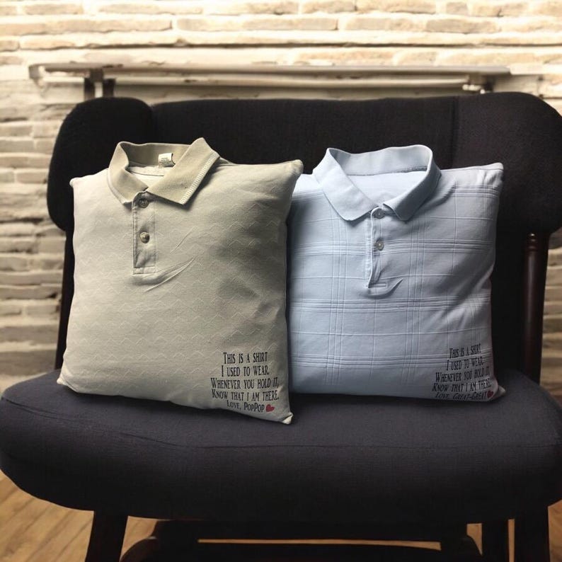 May include: Two square pillows fashioned from polo shirts, one in beige and one in light blue. Each pillow features a collar, a button placket, and black printed text that reads: This is a shirt I used to wear. Whenever you hold it, know that I am there. Love, PopPop and Love, Great-Great.