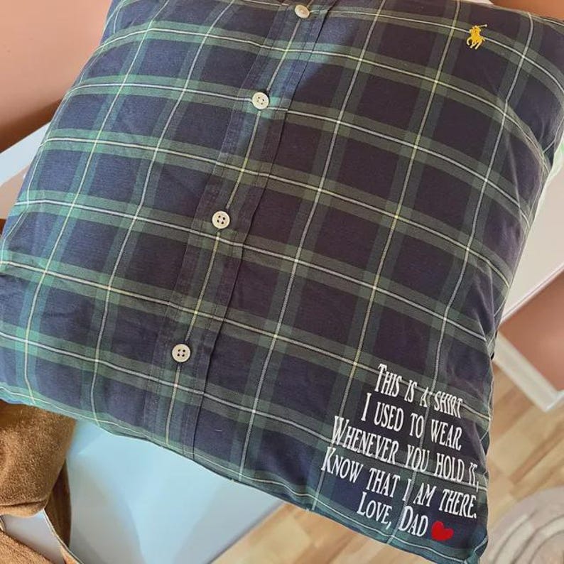 May include: Plaid pillow made from a button-down shirt. The pillow is navy blue and green with white accents. The text "THIS IS A SHIRT I USED TO WEAR...LOVE, DAD" is embroidered on the pillow.