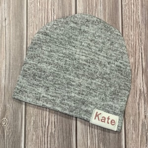 Newborn slouch beanie in blended light gray/white sweater knit White with pink name