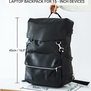 May include: Black leather laptop backpack for 15-inch devices. The bag measures 16.9 inches high, 11.8 inches wide, and 6.7 inches deep. Features include a top handle, adjustable straps, and a front zippered pocket. The text "LAPTOP BACKPACK FOR 15-INCH DEVICES" is at the top.