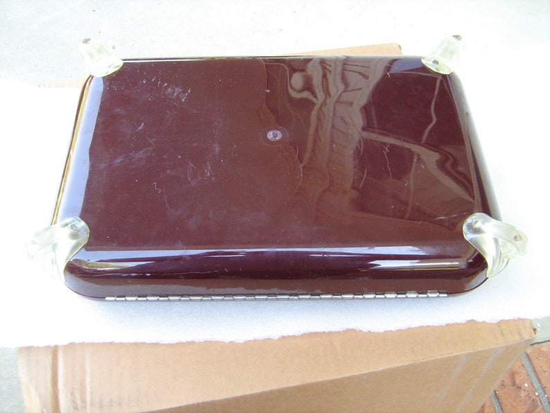 May include: A dark brown rectangular serving tray with clear plastic feet. The tray has a smooth, glossy finish.
