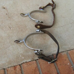 Pair of Marked North and Judd Spurs with 5 Point Star Rowels with Straps