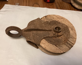 Antique rusty fresh from the farm cast iron and wood wheel pulley. P-2