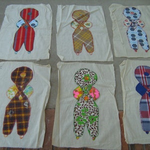 May include: Set of eight handmade fabric doll figures. Each doll is made from different patterned fabrics and has a unique design. The dolls are displayed on white fabric squares.