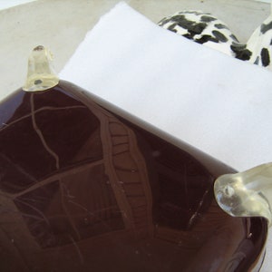 May include: A dark brown serving tray with clear plastic handles. The tray has a smooth, glossy finish and is rectangular in shape.