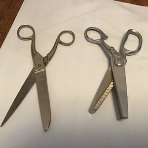 Peut inclure: Deux paires de ciseaux argent&eacute;s. Une paire est un ciseau standard avec une pointe pointue. L'autre paire est une cisaille &agrave; festons avec une lame dentel&eacute;e.