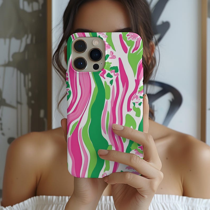 May include: A white phone case with a pink and green abstract swirl pattern. The case has a camera lens cutout.