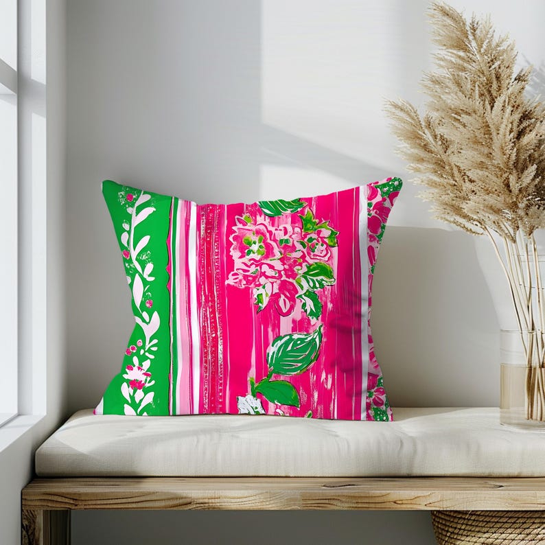 May include: A pink and green patterned cushion with a floral design. The cushion is on a white bench with a wooden base.