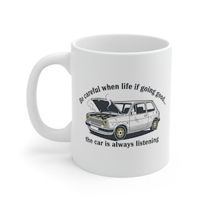 May include: White ceramic mug with a cartoon illustration of a vintage car. The car is beige with gold wheels and its bonnet is open. Text around the car reads, "Be careful when life is going good... the car is always listening."