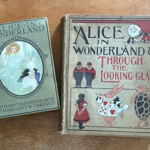 May include: Two vintage books, "Alice in Wonderland" and "Alice in Wonderland & Through the Looking-Glass." The first book is green with an illustration of Alice and a rabbit. The second book has illustrations of characters from the stories.