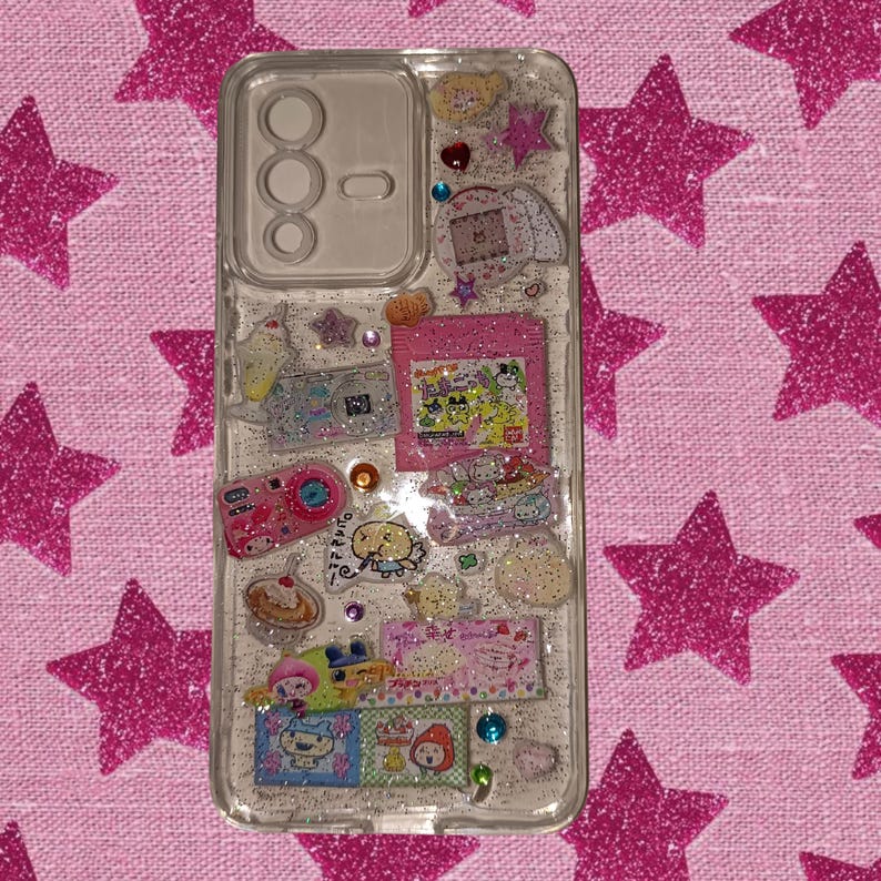Clear resin phone case with kawaii Japanese stickers, glittery silver background, and colorful rhinestones in Y2K aesthetic style.