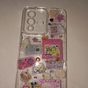 Close-up of holographic glitter phone case featuring pastel stickers, desserts, animals, and cute characters in Juminicore design