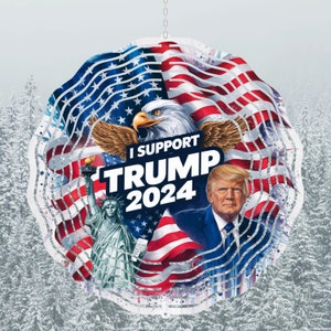 May include: A metal wind spinner with an American flag design. The spinner features a bald eagle, the Statue of Liberty, and the text "I Support Trump 2024".