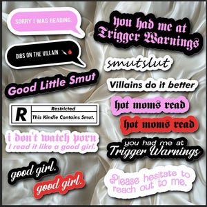 May include: A collection of stickers with various phrases and designs, including "Good Little Smut", "Trigger Warnings", "hot moms read", "Villains do it better", and "Please hesitate to reach out to me".