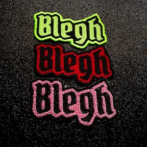 May include: Three embroidered patches featuring the word Blegh in a gothic-style font. The top patch has black lettering with a neon green border, the middle patch has black lettering with a red border, and the bottom patch has black lettering with a pink border.