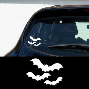 May include: A white vinyl decal of three bats in flight, perfect for adding a spooky touch to a car window.