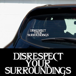 May include: White vinyl sticker with the text "DISRESPECT YOUR SURROUNDINGS" in a gothic font. The sticker is on the back window of a black car.