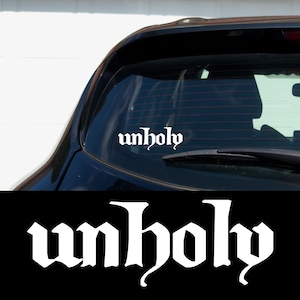 May include: A white vinyl decal with the word "unholy" in a gothic font, applied to the rear window of a black car.