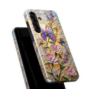 May include: A phone case featuring a stained-glass design with butterflies and flowers. The case has a cream-colored background with purple, pink, and yellow accents. The butterflies have purple and blue wings.