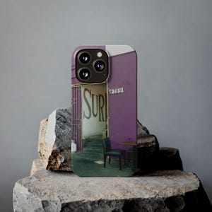 May include: A smartphone case featuring a photographic print of a purple building exterior with the text "SURI" visible on a wall, a metal gate, a dark chair, and the number "8759" displayed above the entrance, with a triple camera cutout.