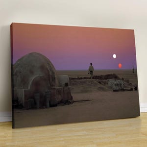 Puede incluir: Impresión en lienzo que representa un paisaje desértico bajo un cielo vibrante al atardecer. La escena presenta una estructura en forma de cúpula, una figura y dos soles. La obra de arte evoca un tema de ciencia ficción, con tonos cálidos.