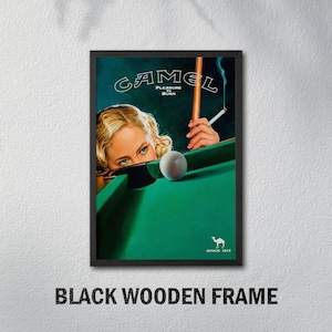 K&ouml;nnte beinhalten: Gerahmte Vintage-Werbung mit einer Frau beim Billard, dem Camel-Logo und dem Text "Pleasure to Burn". Das Bild zeigt einen gr&uuml;nen Billardtisch, eine brennende Zigarette und eine wei&szlig;e Kugel. Der Rahmen ist schwarz.