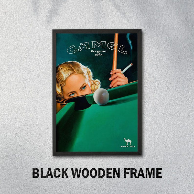 K&ouml;nnte beinhalten: Gerahmte Vintage-Werbung mit einer Frau beim Billard, dem Camel-Logo und dem Text "Pleasure to Burn". Das Bild zeigt einen gr&uuml;nen Billardtisch, eine brennende Zigarette und eine wei&szlig;e Kugel. Der Rahmen ist schwarz.