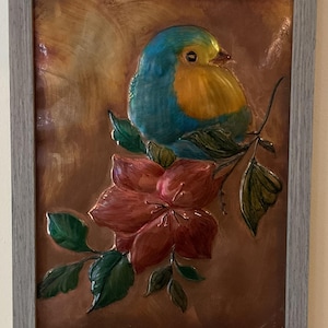 Bluebird and flower copper embossed art. Mounted in a 9x12 distressed gray frame with tabletop and wall mounting options.