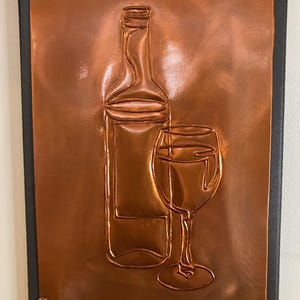 Wine bottle and glass copper embossed art. Minimalist 9x12 design with table top and wall mounting options. Mounted on a gray canvas frame.