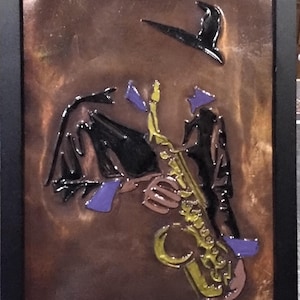 Minimalist saxophonist copper embossed art. Mounted in a 9x12 distressed black frame with tabletop and wall mounting options.