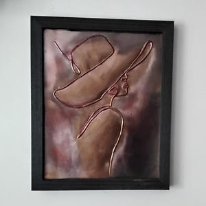 Woman with hat copper embossed art. Minimalist design in a distressed black 8 x 10 pine frame with tabletop and wall mounting options.