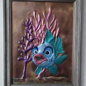 Happy fish copper embossed art. Mounted in a 9x12 distressed brown toned frame with tabletop and wall mounting options.