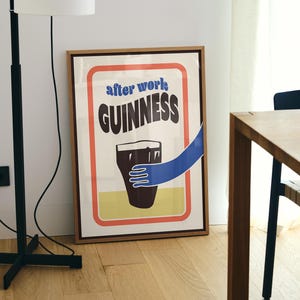 Op de afbeelding: Een ingelijste poster met een vintage ontwerp met een glas Guinness-bier en de tekst "after work: GUINNESS".