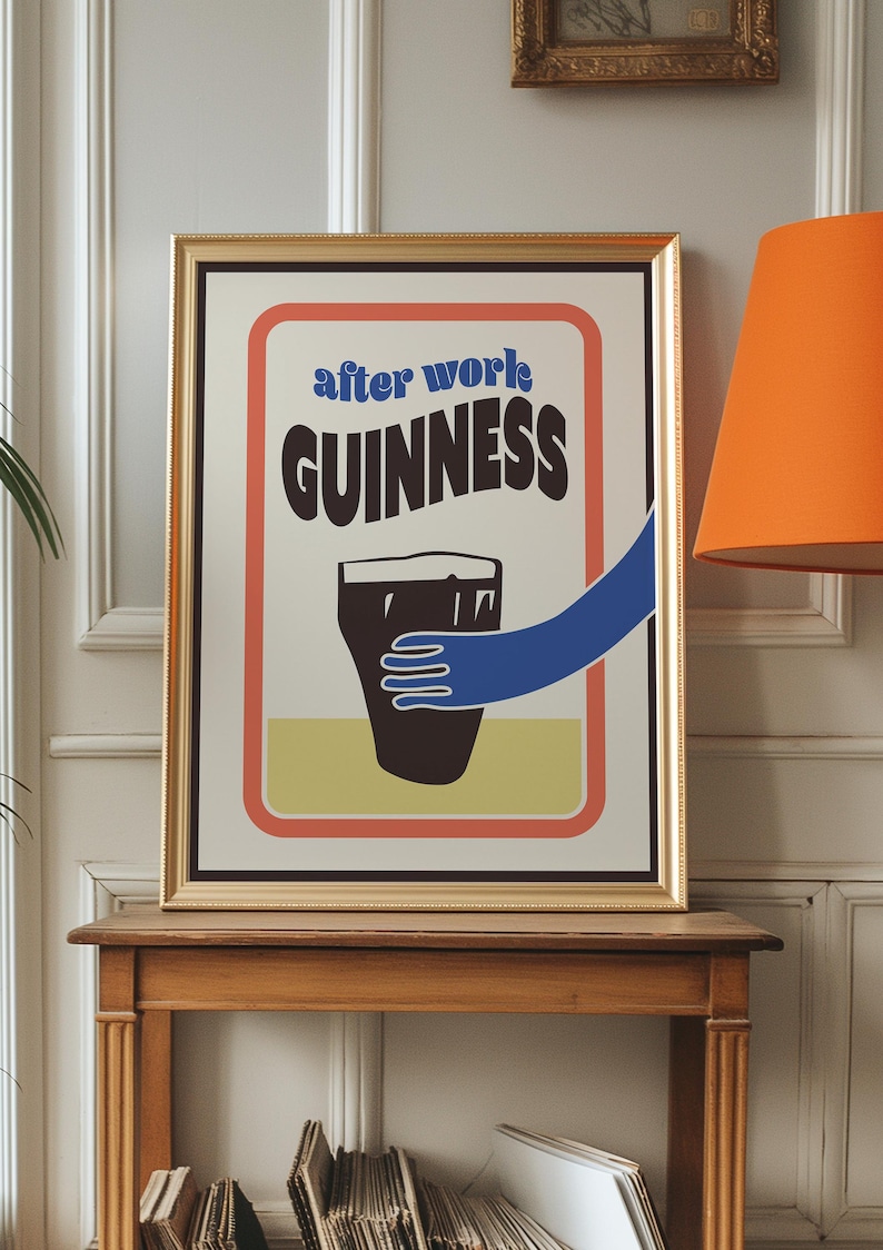 Op de afbeelding: Een ingelijste poster met een vintage ontwerp met een glas Guinness-bier met de tekst "after work GUINNESS" in blauw en rood.