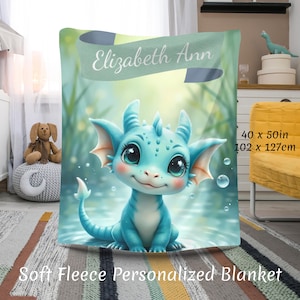 May include: Soft fleece personalized blanket with a cute blue dragon illustration. The blanket measures 102 x 127cm and has the name "Elizabeth Ann" on a banner. The dragon has large eyes and is set against a watery background.