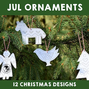 May include: Four white paper Christmas ornaments hanging on a green pine tree branch. The ornaments are a bird, a reindeer, a tree, and an angel. The ornaments are decorated with small holes for stitching. The text "JUL ORNAMENTS" is at the top of the image and "12 CHRISTMAS DESIGNS" is at the bottom.