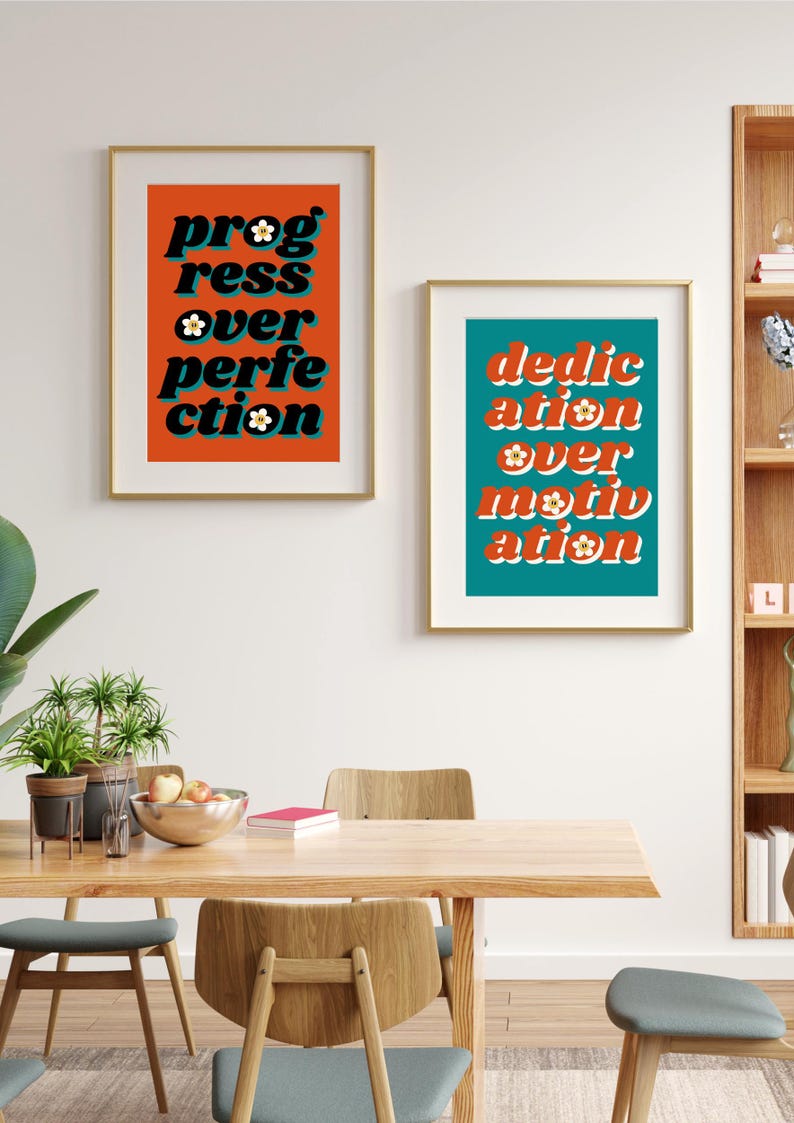 May include: Two framed prints with motivational quotes in a retro style. The print on the left has an orange background with the text "progress over perfection" in black with white flowers. The print on the right has a teal background with the text "dedication over motivation" in black with white flowers.