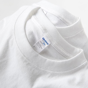 May include: Two white crew neck t-shirts are stacked, with the top shirt's collar and label visible. The label reads "Gildan Premium Cotton" and includes size "S". The shirts are made of a soft, plain white fabric.
