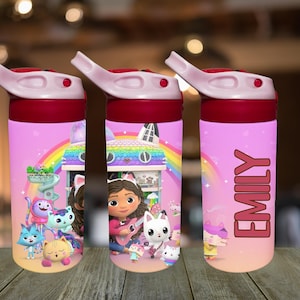 Könnte beinhalten: Rosa Wasserflaschen mit rotem Deckel und weißem Ausguss. Die Flaschen zeigen ein Cartoon-Design mit einem Regenbogen, einem Haus und dem Namen "EMILY". Die Flaschen sind mit Cartoon-Figuren verziert.