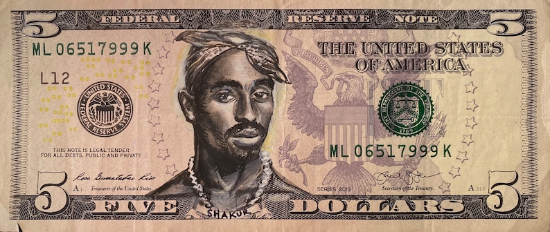 May include: A five dollar bill with a portrait of rapper Tupac Shakur drawn on it. The bill has the text "ML 06517999 K" printed on it.