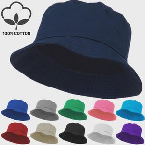 May include: A navy blue bucket hat made from 100% cotton. The image displays the hat in a range of colours: blue, grey, green, pink, turquoise, red, beige, black, white, and purple. The hat features a wide brim and a classic design.