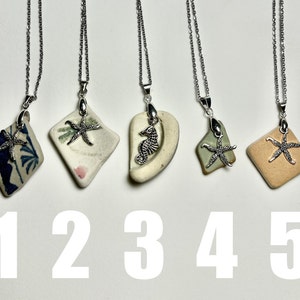 May include: Five silver necklaces with different charms. The charms are made of ceramic and feature a starfish, a seahorse, and a seashell. The necklaces are on a white background.