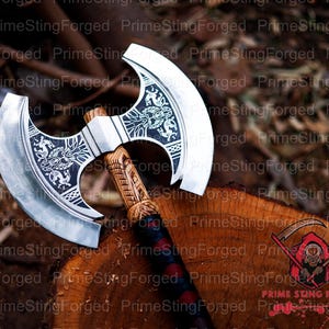May include: A silver and black double-bladed axe with intricate etched designs on the blades and a wooden handle. The handle is carved with detailed patterns. The axe is displayed on a wooden surface.