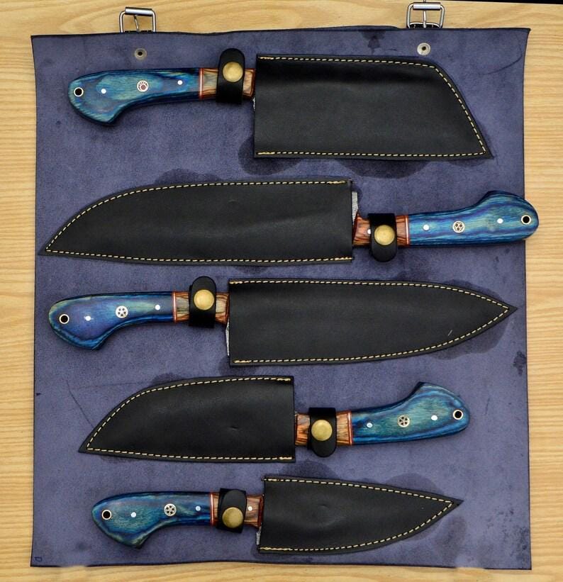 May include: Set of five kitchen knives with blue and black handles and leather sheaths. The knives are arranged in a row on a blue background.