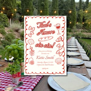 Puede incluir: Una invitación blanca con texto rojo e ilustraciones. El texto dice "That's Amore cin cin!" e incluye los detalles de una despedida de soltera. Las ilustraciones incluyen una copa de vino, una barra de pan, un limón y pasta.